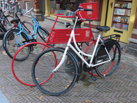 851096 Afbeelding van geparkeerd fietsen, waartussen de rode reclamefiets 'Stadhuiskwartier' in de Minrebroederstraat ...